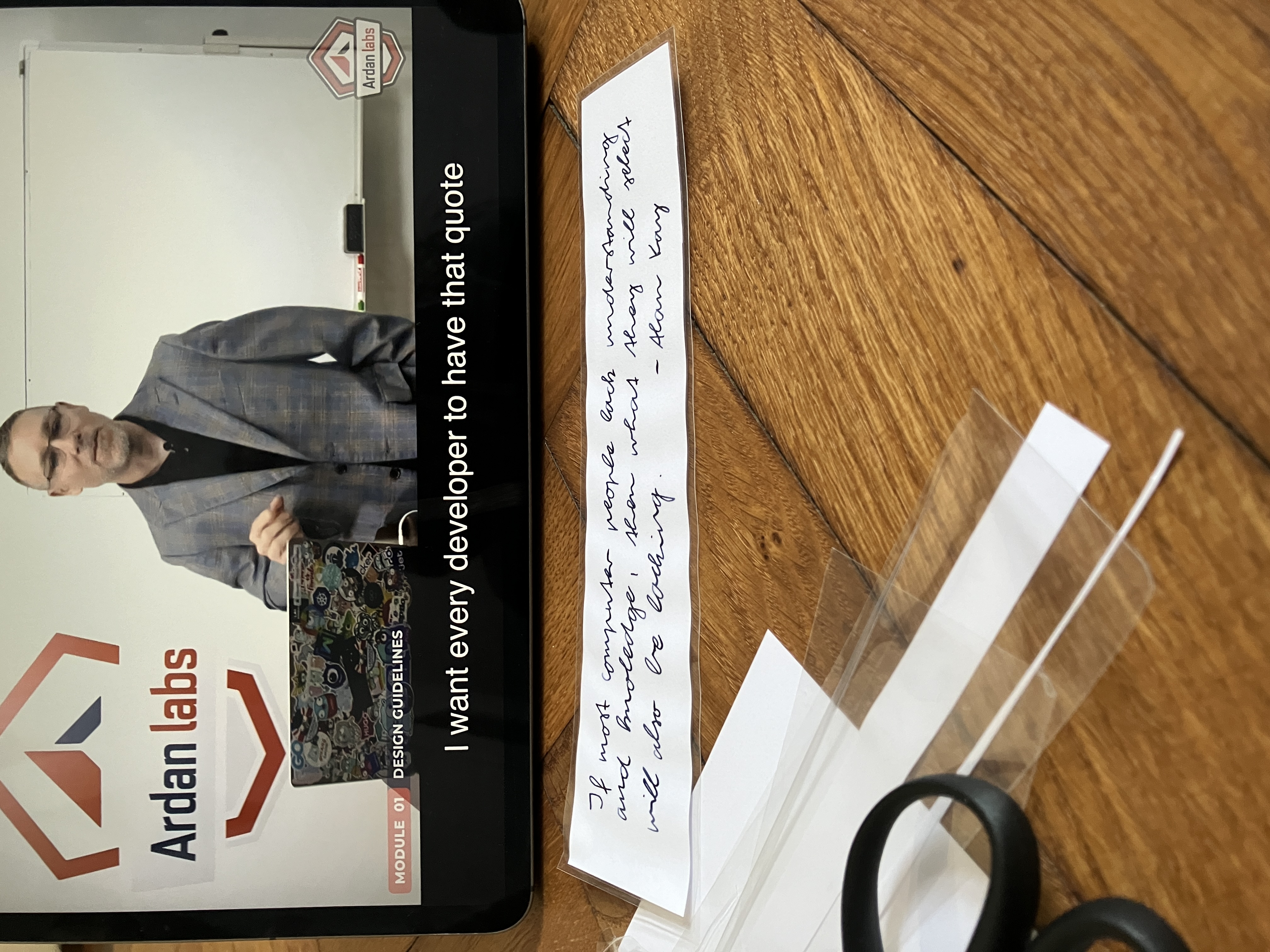 Photo of the course on video on a tablet and a laminated piece of paper with the quote on it.